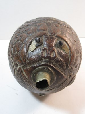 Lot 159 - AN EARLY 19TH CENTURY CARVED COCONUT BUGBEAR POWDER FLASK